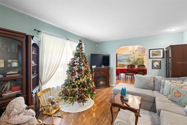 living room with light hardwood / wood-style floors and a notable chandelier