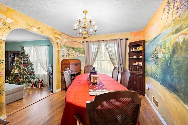 dining room featuring a chandelier, hardwood / wood-style floors, and a textured ceiling