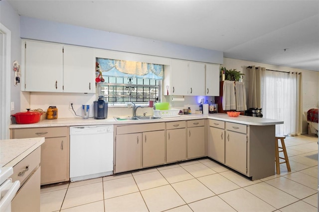 kitchen featuring sink, white dishwasher, and light tile patterned floors