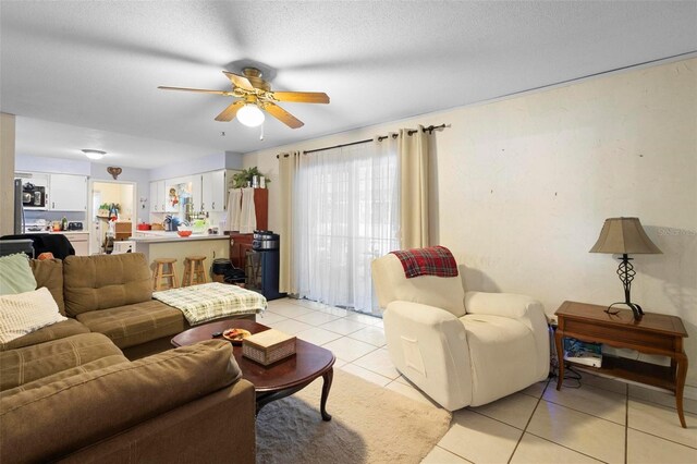 tiled living room featuring ceiling fan and a textured ceiling