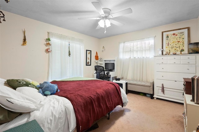 carpeted bedroom with a textured ceiling and ceiling fan