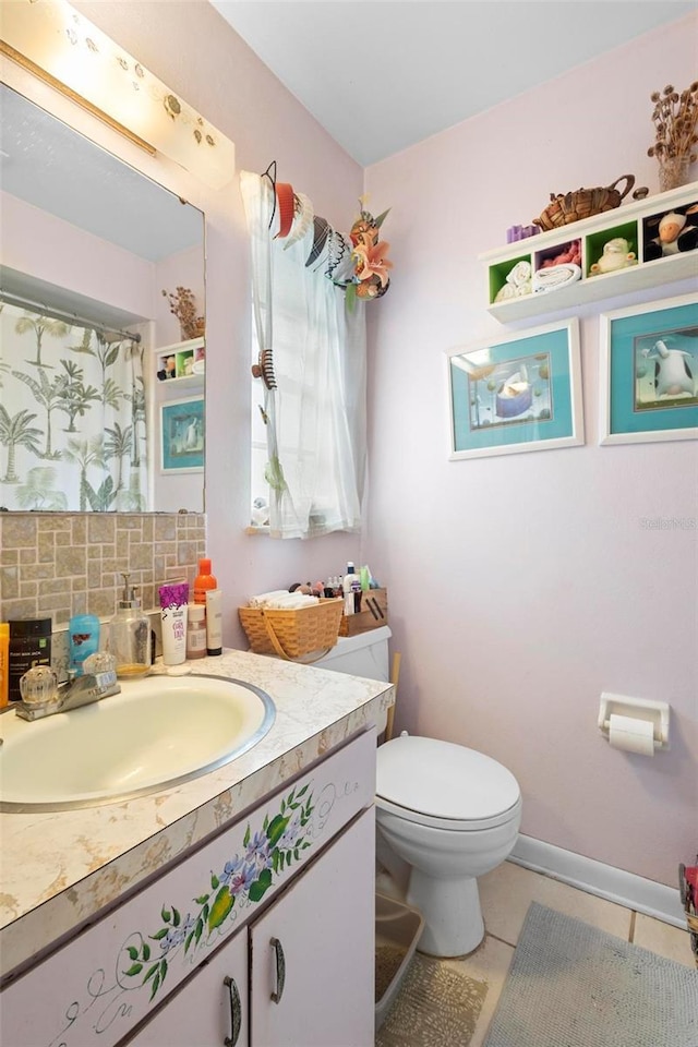 bathroom featuring decorative backsplash, tile patterned flooring, vanity, and toilet