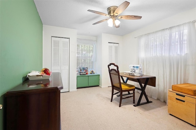 home office featuring ceiling fan and light carpet