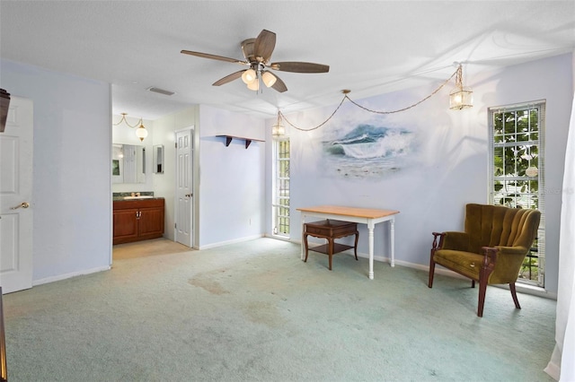 living area with light colored carpet and ceiling fan