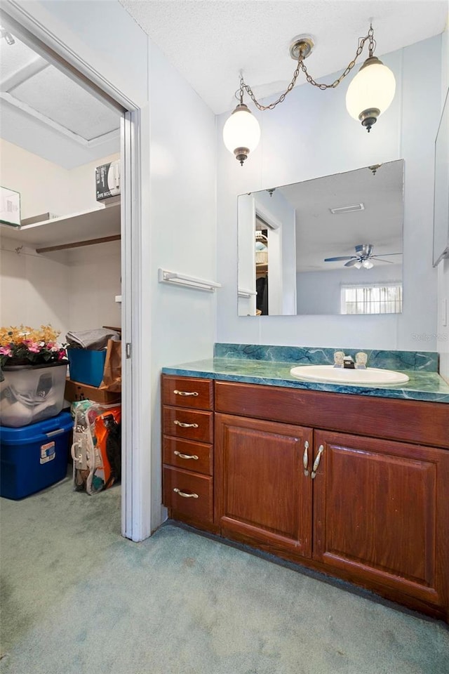 bathroom with a textured ceiling, vanity, and ceiling fan