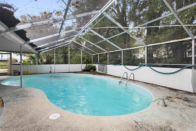 view of pool featuring glass enclosure