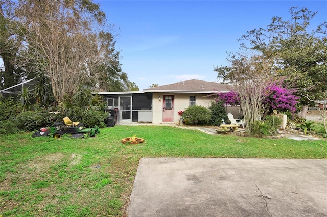 view of front of home featuring a patio area, a sunroom, and a front yard