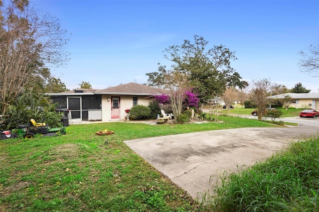 ranch-style house with a sunroom and a front yard