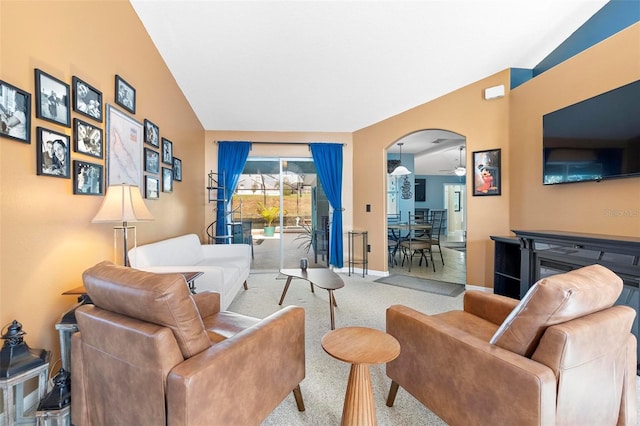 carpeted living room with ceiling fan and lofted ceiling