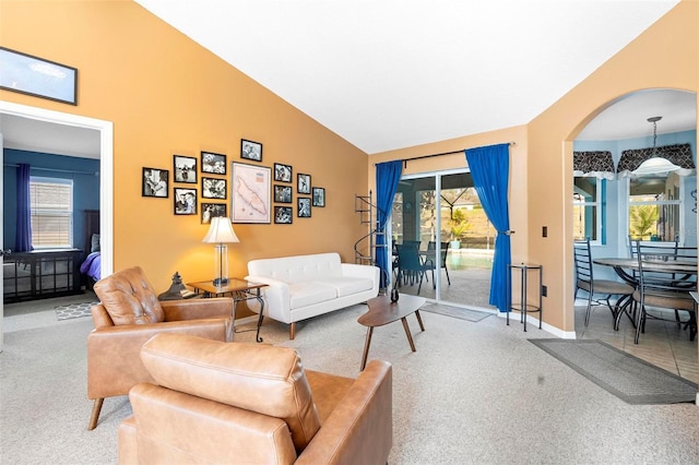 living room with lofted ceiling, light carpet, and a wealth of natural light