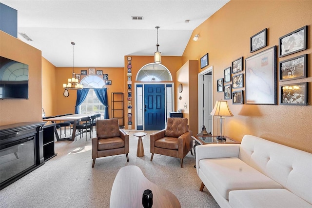 carpeted living room featuring lofted ceiling and an inviting chandelier