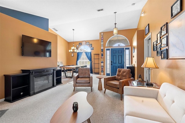 living room featuring light colored carpet, lofted ceiling, and a chandelier