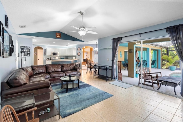 tiled living room featuring ceiling fan, a textured ceiling, and vaulted ceiling