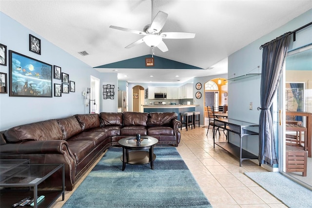 living room with ceiling fan, light tile patterned flooring, and lofted ceiling