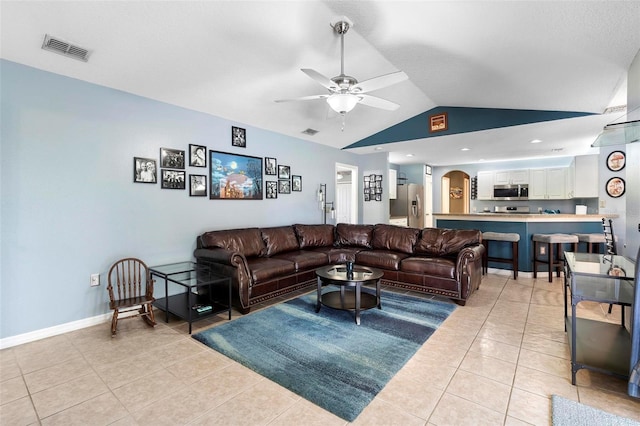 living room featuring ceiling fan, light tile patterned floors, and lofted ceiling