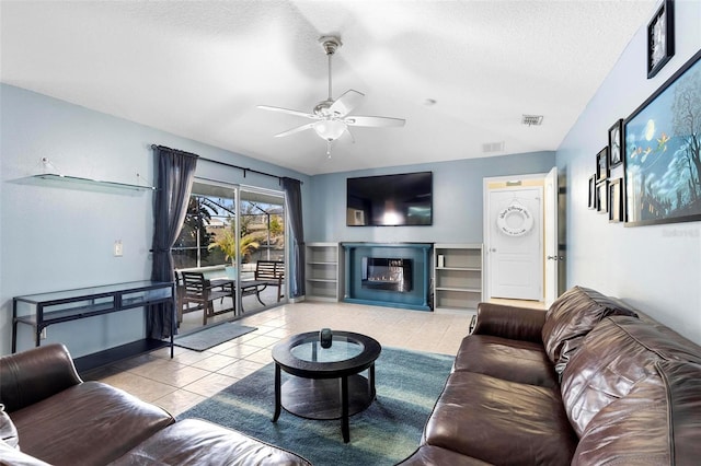 living room featuring ceiling fan and a textured ceiling