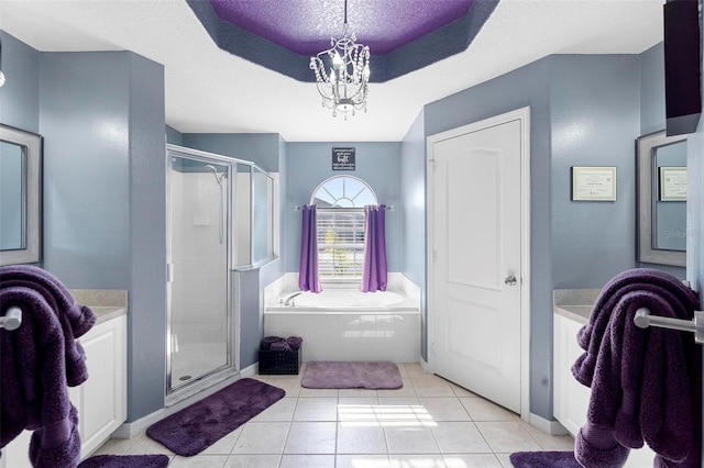 bathroom with tile patterned floors, a raised ceiling, a chandelier, and shower with separate bathtub