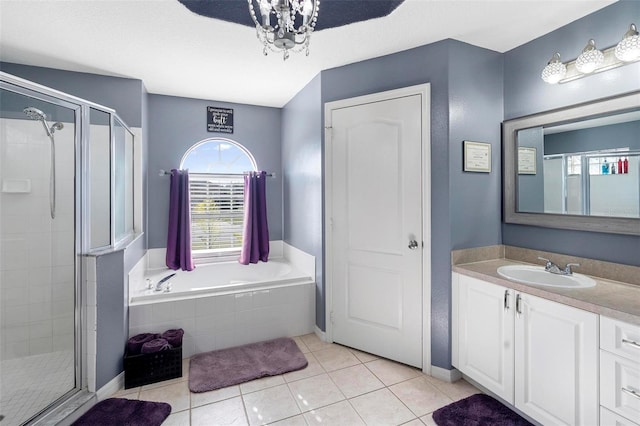 bathroom featuring tile patterned flooring, vanity, an inviting chandelier, and separate shower and tub