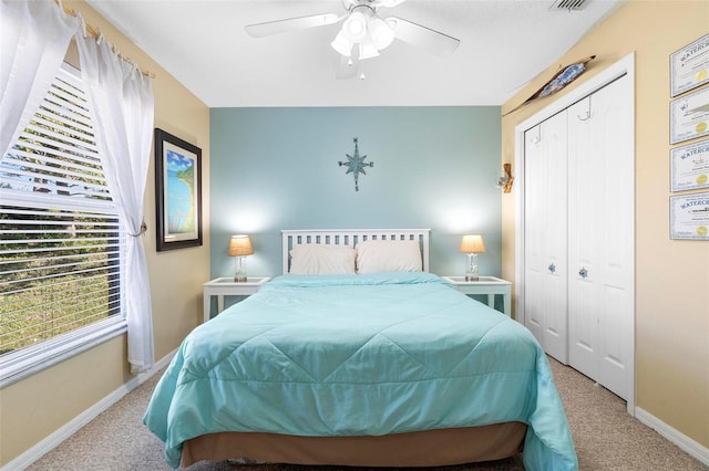 bedroom with ceiling fan, light carpet, and a closet