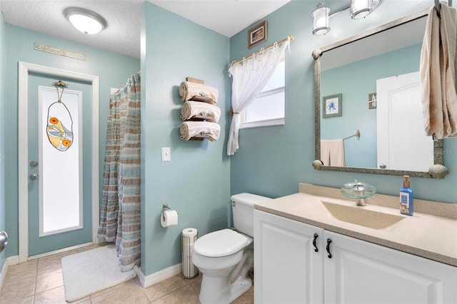 bathroom featuring tile patterned flooring, vanity, toilet, and a textured ceiling