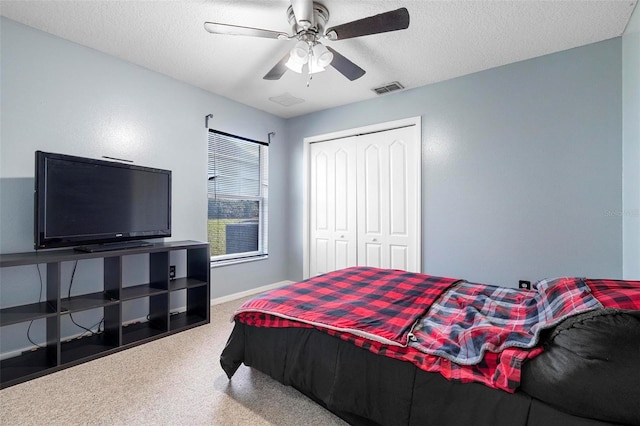 carpeted bedroom with a textured ceiling, a closet, and ceiling fan