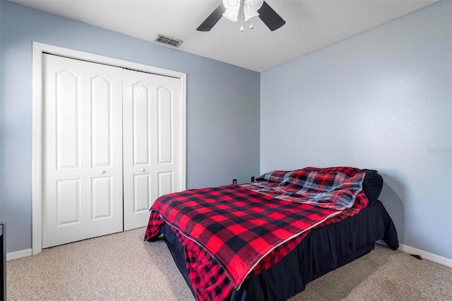 carpeted bedroom featuring ceiling fan and a closet