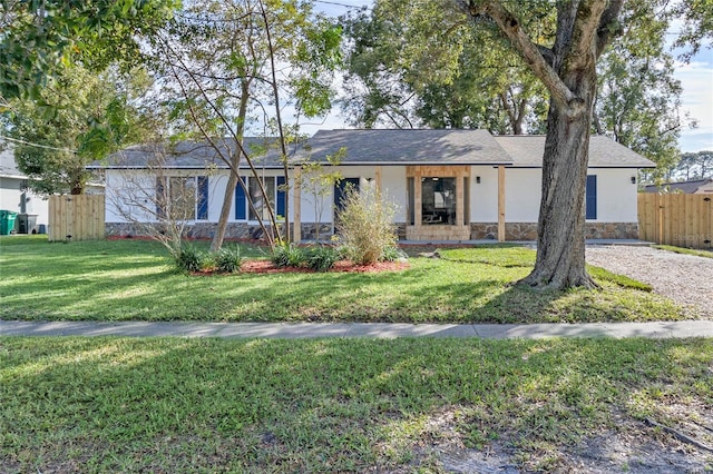 5355 Fay Blvd, Cocoa, FL 32927 - ranch-style home featuring stucco siding, a front lawn, fence, and stone siding