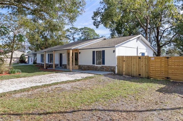 5355 Fay Blvd, Cocoa, FL 32927 - view of front of property featuring a gate, stone siding, a front lawn, and fence