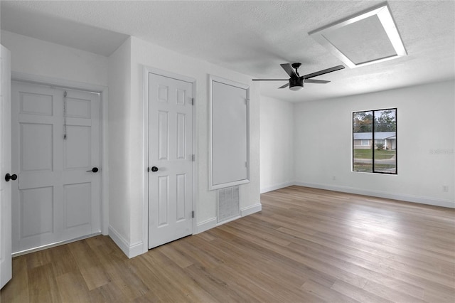 5355 Fay Blvd, Cocoa, FL 32927 - unfurnished bedroom featuring a textured ceiling, attic access, light wood-type flooring, baseboards, and visible vents