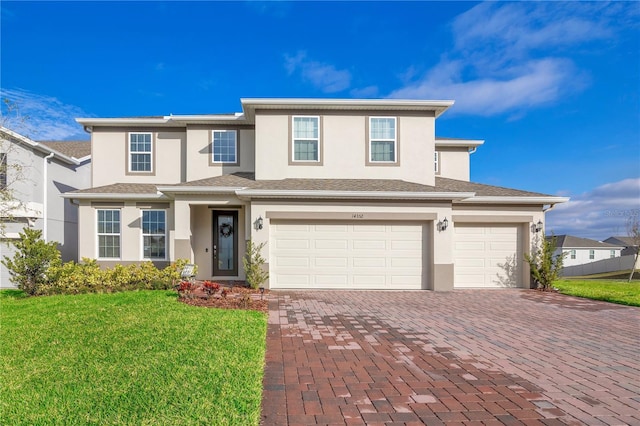 view of front of property featuring an attached garage, a front lawn, decorative driveway, and stucco siding