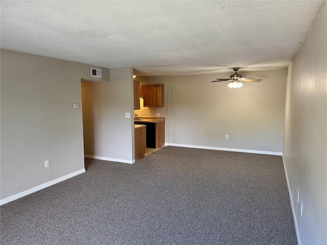 unfurnished living room featuring ceiling fan, carpet floors, and a textured ceiling