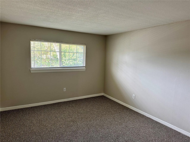 carpeted spare room with a textured ceiling