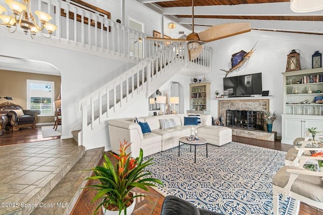 living room featuring wood ceiling, beam ceiling, high vaulted ceiling, a fireplace, and a chandelier