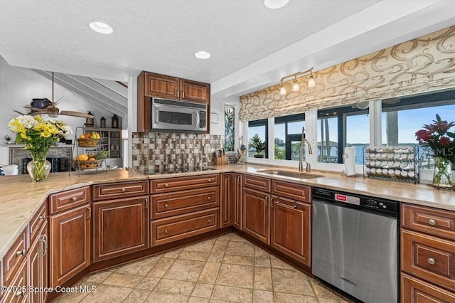 kitchen featuring lofted ceiling, sink, decorative backsplash, light tile patterned floors, and appliances with stainless steel finishes