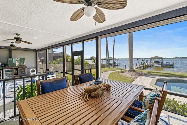 sunroom / solarium featuring a water view and ceiling fan