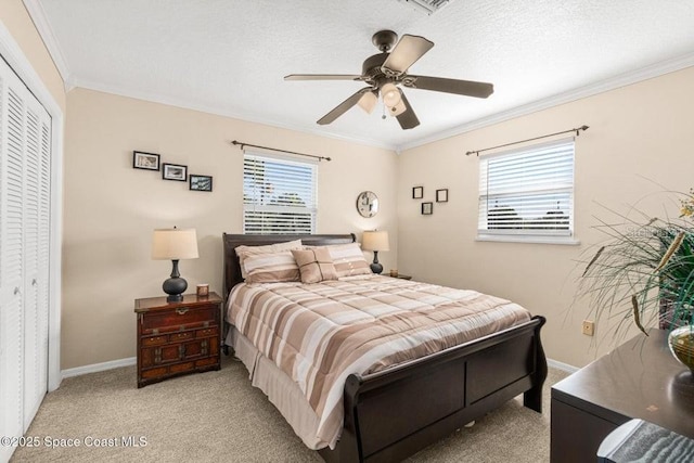 bedroom with ceiling fan, light colored carpet, crown molding, and a closet