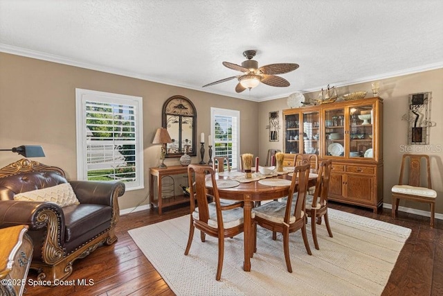 dining area with ceiling fan, ornamental molding, a textured ceiling, and dark wood-type flooring