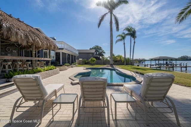 view of pool featuring a patio area, a yard, and a water view