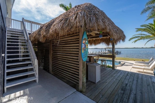 view of dock featuring a swimming pool side deck with water view