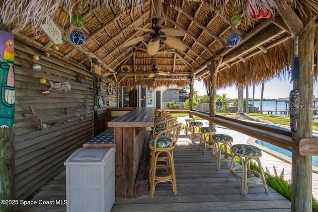 exterior space featuring a gazebo, ceiling fan, a water view, and exterior bar