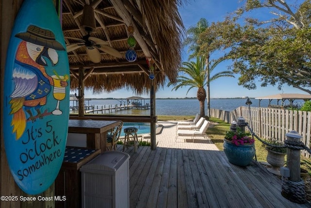 wooden terrace with ceiling fan and a water view