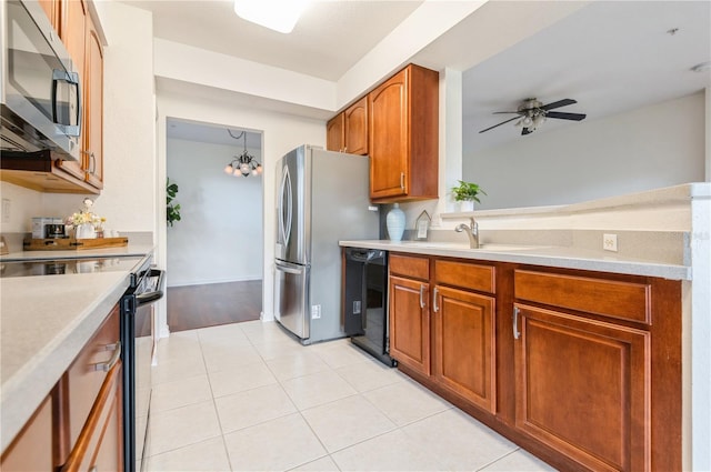 kitchen featuring tasteful backsplash, ceiling fan with notable chandelier, stainless steel appliances, sink, and light tile patterned flooring