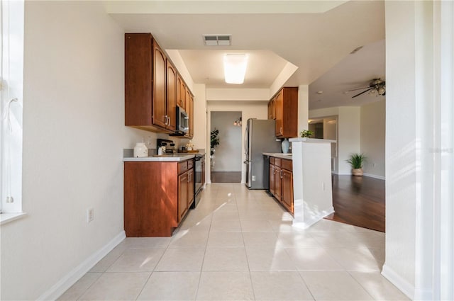 kitchen with ceiling fan, light tile patterned floors, and appliances with stainless steel finishes