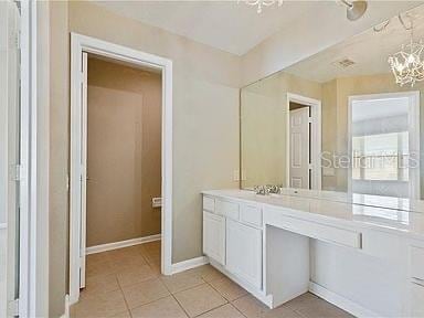 bathroom with tile patterned flooring, vanity, and an inviting chandelier