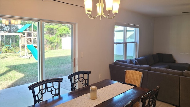 dining room featuring a wealth of natural light and an inviting chandelier