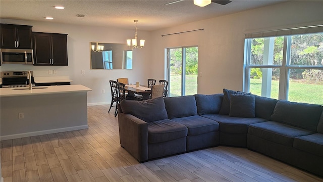 living room featuring plenty of natural light, light wood-type flooring, and sink