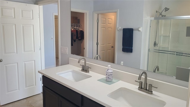 bathroom featuring tile patterned flooring, vanity, and a shower with shower door