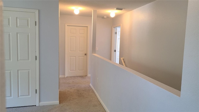 hallway with light colored carpet