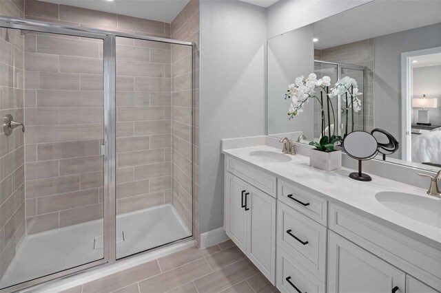 bathroom featuring tile patterned floors, a shower with door, and vanity