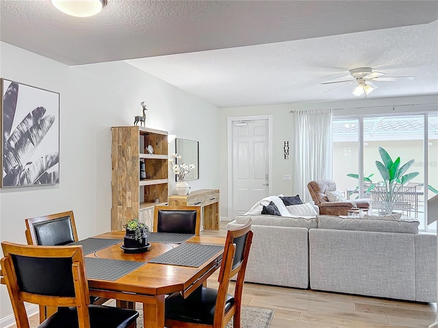 dining area featuring a textured ceiling, light hardwood / wood-style flooring, and ceiling fan